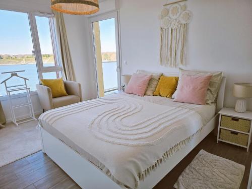a bedroom with a bed with a view of the water at Lakeside Provence - Appartement 4 étoiles face au lac de Monteux in Monteux