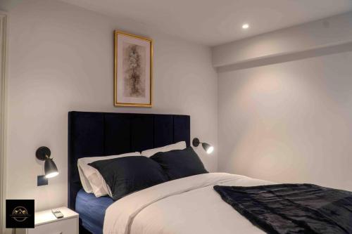 een slaapkamer met een bed met een zwart hoofdeinde bij Lovely 3-Bed Apartment in Altrincham in Altrincham
