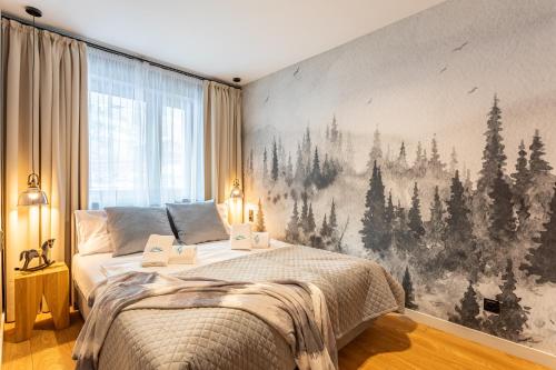 a bedroom with a large mural of trees on the wall at Mountain Tree Apartament C27 Apart Invest in Szklarska Poręba