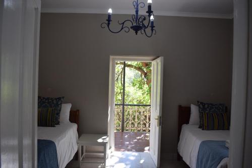 a room with two beds and a chandelier at The Baths Natural Hot Springs in Citrusdal