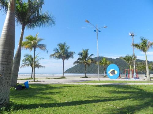 a park with palm trees and a playground on the beach at Pousada Acqua Bella PISCINA CLIMATIZADA in Bertioga