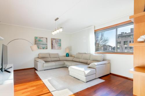 a living room with white furniture and a large window at Host Wise - Gorgeous Spacious Flat - Ace Location in Porto