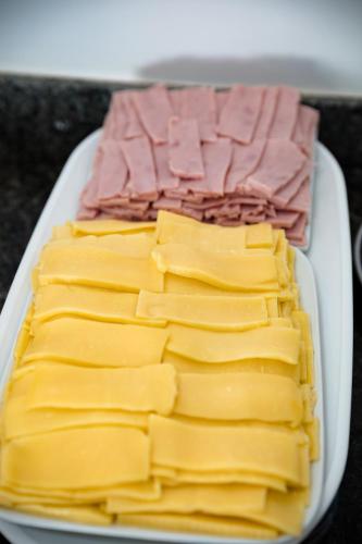 a tray of cheese and ham on a table at Moriah Maceió Beach Hotel in Maceió