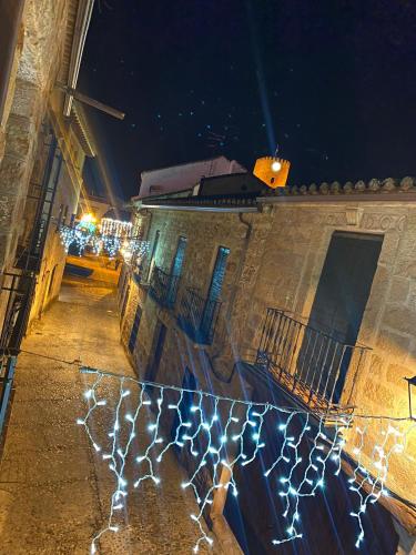 a string of lights on the side of a building at night at Refugio de Baños in Baños de la Encina