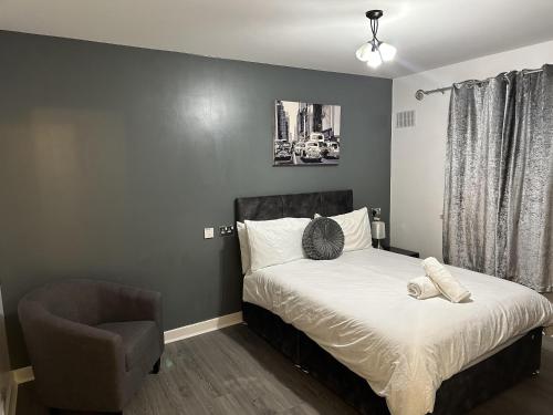 a bedroom with a bed and a chair at Remarkable 2-Bed Apartment in Wolverhampton in Wolverhampton