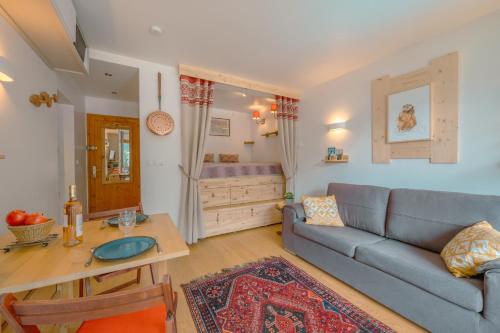 uma sala de estar com um sofá e uma mesa em Les Marmottes d'Argentière - Happy Rentals em Chamonix-Mont-Blanc