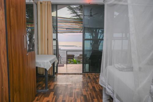 una camera con letto e vista sull'oceano di Kashinath Beach Huts ad Agonda