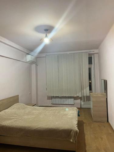 een slaapkamer met een bed en een plafondventilator bij Malibui aygi in Jerevan