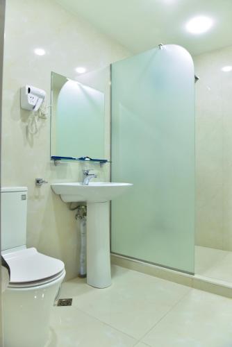 a bathroom with a toilet and a sink and a mirror at Macao Hotel in Yerevan