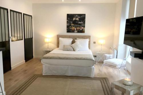 a bedroom with a large white bed with two lamps at Amazing Résidence proche Galeries Lafayette in Paris