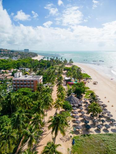 an aerial view of a beach with palm trees and a hotel at Moriah Maceió Beach Hotel in Maceió