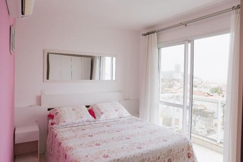 a white bedroom with a bed and a large window at Ap 3 quartos em home club - Beto Carrero/Penha in Penha