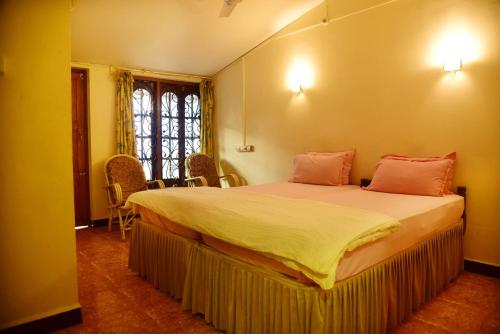 ein Schlafzimmer mit einem großen Bett mit rosa Kissen in der Unterkunft Hotel My Soulmate, Palolem Beach in Palolem