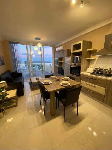 eine Küche und ein Wohnzimmer mit einem Tisch und Stühlen in der Unterkunft Marsaskala 1 bedroom penthouse in Marsaskala