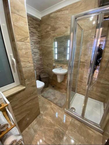 ein Bad mit einer Dusche, einem WC und einem Waschbecken in der Unterkunft Marsaskala 1 bedroom penthouse in Marsaskala