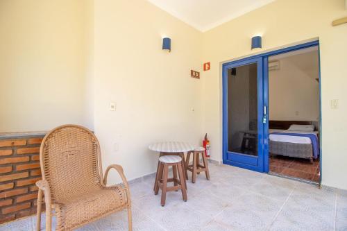 a room with a table and chairs and a bed at Mirante Praia Hotel in Olímpia