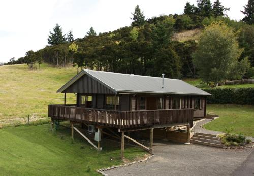 a large wooden house on a grassy hill at Greenacres Alpine Chalets & Villas in Hanmer Springs