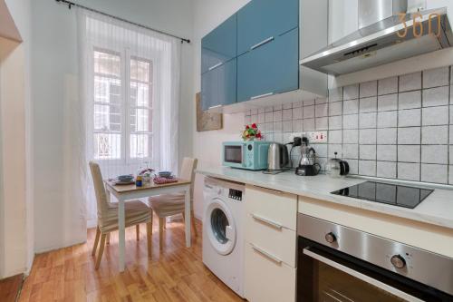 a kitchen with a sink and a washing machine at Sweet Stay Floriana Studios in Il-Furjana