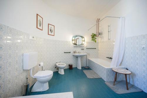 La salle de bains est pourvue de toilettes, d'une baignoire et d'un lavabo. dans l'établissement Villa Calicantus, à Bardolino