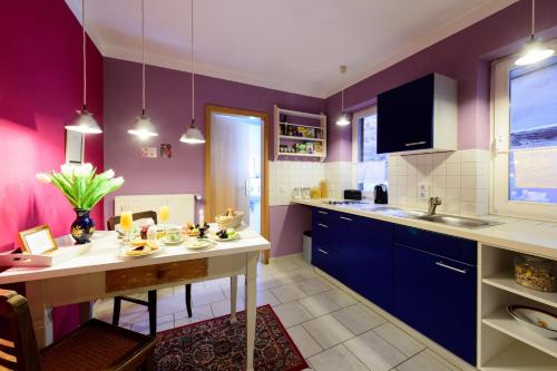 eine Küche mit lila Wänden und einem Esstisch in der Unterkunft Kleine13 (Hohe13) in Quedlinburg