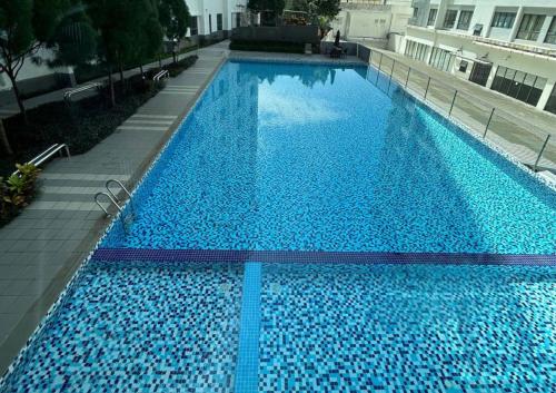 a large blue swimming pool in a building at Beauty Park View Stay Above DPulze Mall #DP3 in Cyberjaya