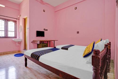 two beds in a room with pink walls at OYO Hotel SS Residency in Punalūr