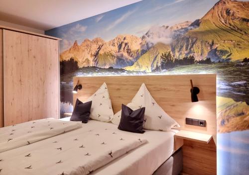 a bedroom with a mountain mural on the wall at Gschwenderhaus Ferienwohnungen in Oberstdorf