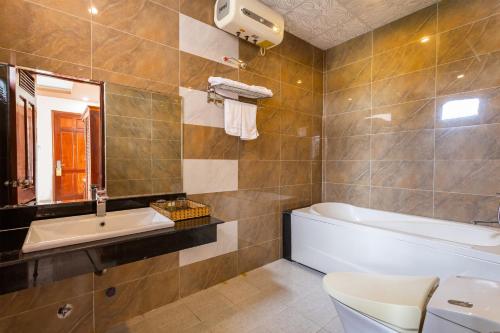 a bathroom with a bath tub and a sink at Phu Van Resort & Spa in Phú Quốc