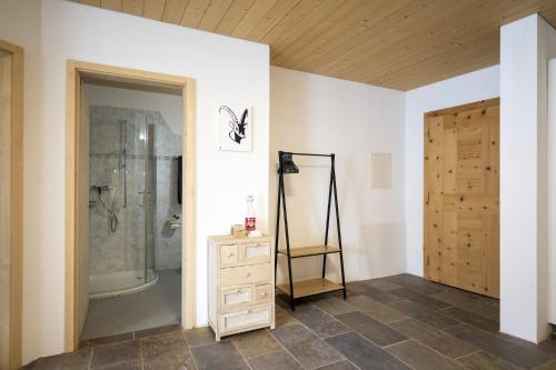 ein Badezimmer mit einer Dusche und einer Holztür in der Unterkunft Chasa Chavrioel in Sent