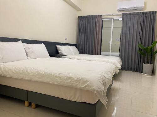 a bedroom with two beds and a window at 慢慢 相遇 in Taitung City