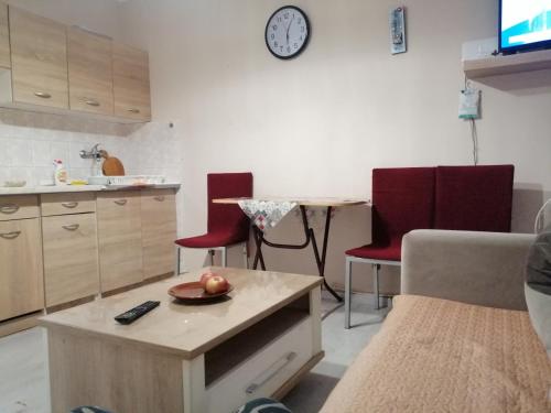 uma cozinha com cadeiras vermelhas e uma mesa com uma tigela de fruta em Квартира 200м от моря. em Bar