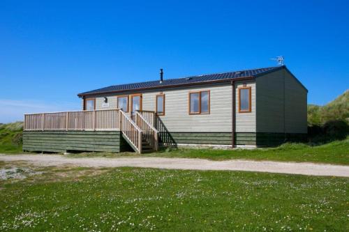 a green and white house with a porch at Perranporth Golf Club Self-Catering Holiday Accommodation in Perranporth