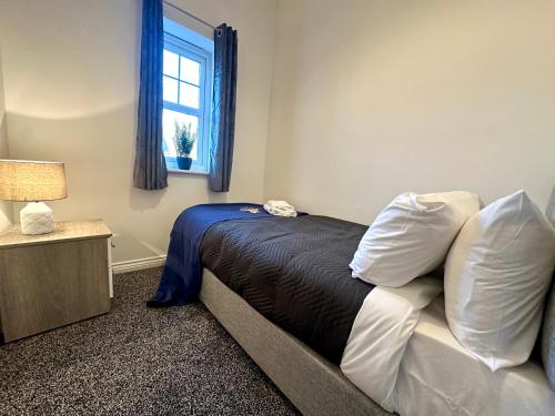 um quarto com uma cama com almofadas e uma janela em Wallis House by Blue Skies Stays em Stockton-on-Tees