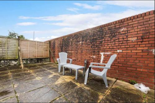 two chairs and a table on a brick wall at Ensuite Room in Cardiff City Centre in Cardiff