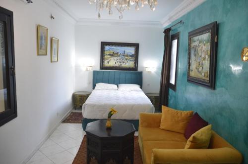 sypialnia z łóżkiem i kanapą w obiekcie Riad Baddi w mieście Sala