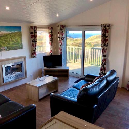 a living room with a couch and a tv and a fireplace at Perranporth Golf Club Self-Catering Holiday Accommodation in Perranporth