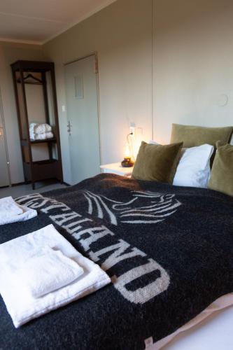 a bedroom with a bed with towels on it at Hestaland Guesthouse Horse Farm Stay in Staðarhús