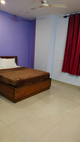 1 dormitorio con 1 cama con cortina roja en Town gate en Madikeri