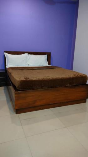 1 cama con marco de madera en una habitación en Town gate en Madikeri