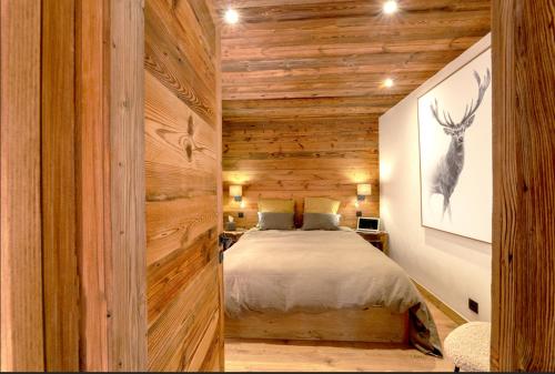a bedroom with a bed in a room with wooden walls at Modern apartment in Megeve near ski lifts in Megève