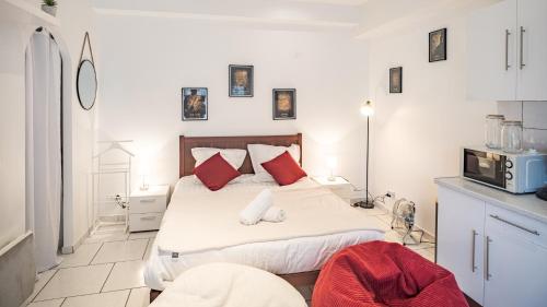 une chambre avec un grand lit avec des oreillers rouges dans l'établissement Smart Confort 1 - studio Confort et Stylé, à Troyes