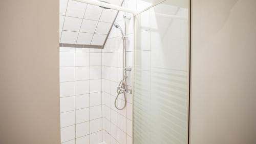 La salle de bains est pourvue d'une douche avec du carrelage blanc. dans l'établissement Smart Confort 1 - studio Confort et Stylé, à Troyes