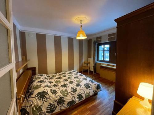 a bedroom with a bed and a desk and a window at Villa Gatti [Limone Centro] in Limone Piemonte