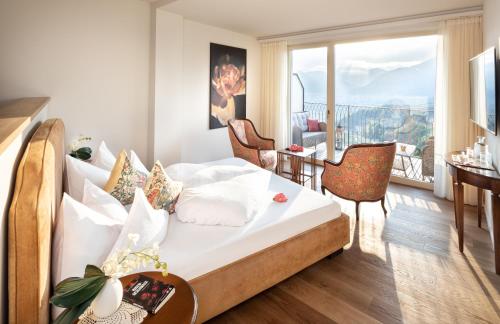 ein Hotelzimmer mit einem Bett und einem Balkon in der Unterkunft Schloss Hotel Korb in Appiano sulla Strada del Vino