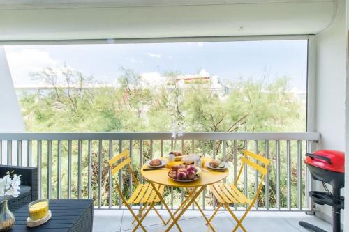 une table avec une assiette de nourriture sur un balcon dans l'établissement Chemin de la Plage*Clim* Plage à 5 min * Terrasse, à La Grande Motte