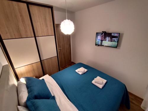 a bedroom with a blue bed with two towels on it at Apartman Grujanac in Zlatibor