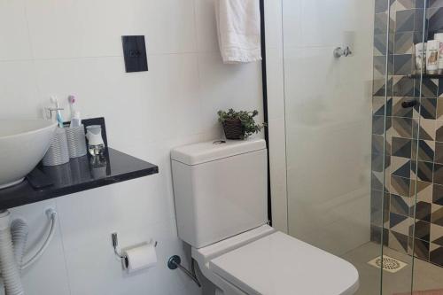 een witte badkamer met een toilet en een wastafel bij Casa inteira, novíssima, 3 quartos, 2 BH, 800m da UFJF in Juiz de Fora