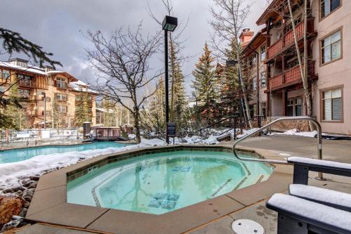 a swimming pool with snow on the ground and buildings at Powderhorn Lodge 102: Sego Lily Suite in Solitude