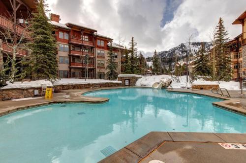 una piscina en un complejo con árboles nevados en Powderhorn Lodge 102: Sego Lily Suite, en Solitude