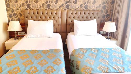 a hotel room with two beds and two lamps at Old Port Hotel in Istanbul